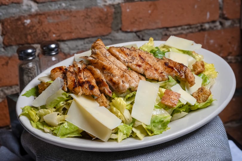 Fresh grilled chicken Caesar salad with shaved Parmesan, croutons, and crisp romaine lettuce.